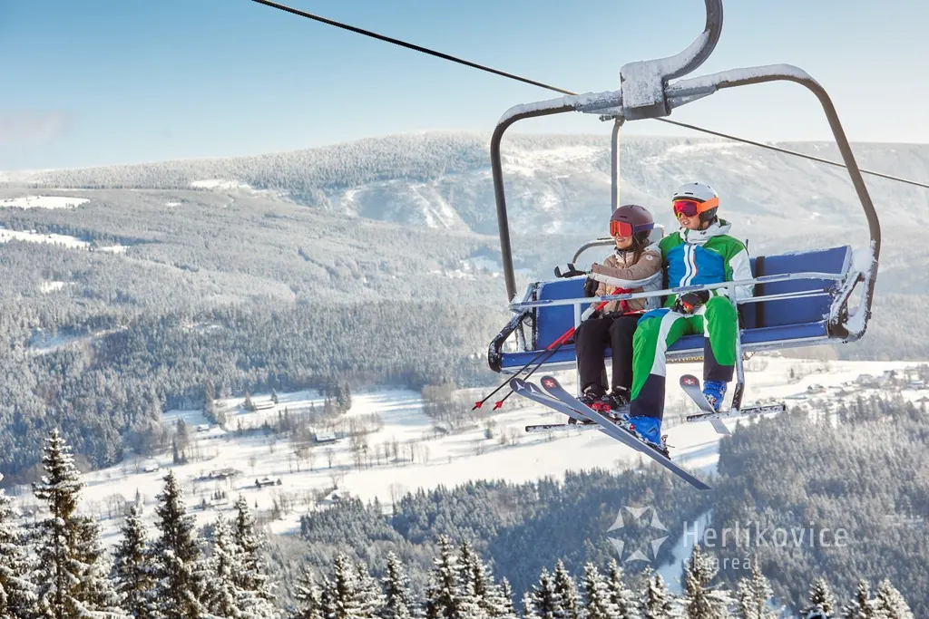 Rodina na čtyřsedačkové lanovce na Žalý nad zasněženým údolím
